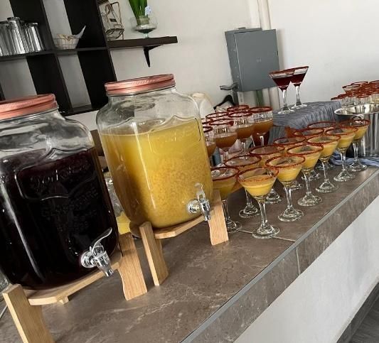 Vitroleros con aguas frescas y copas en la barra