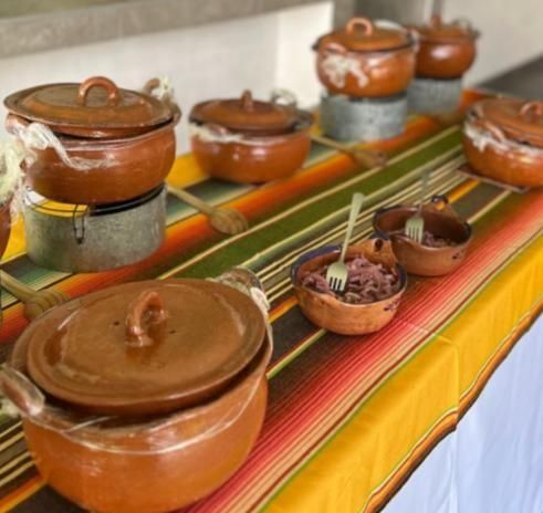 Cazuelas de barro sobre un mantel de colores en la mesa de buffet