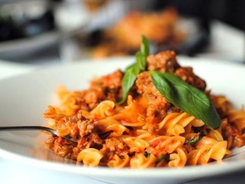 Plato de pasta con salsa de carne y albahaca