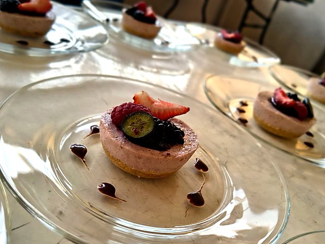 Cheesecake de frutos rojos emplatado con salsa de chocolate