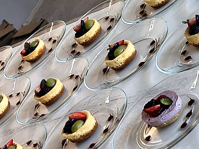 Cheesecakes con frutos rojos emplatados para un evento